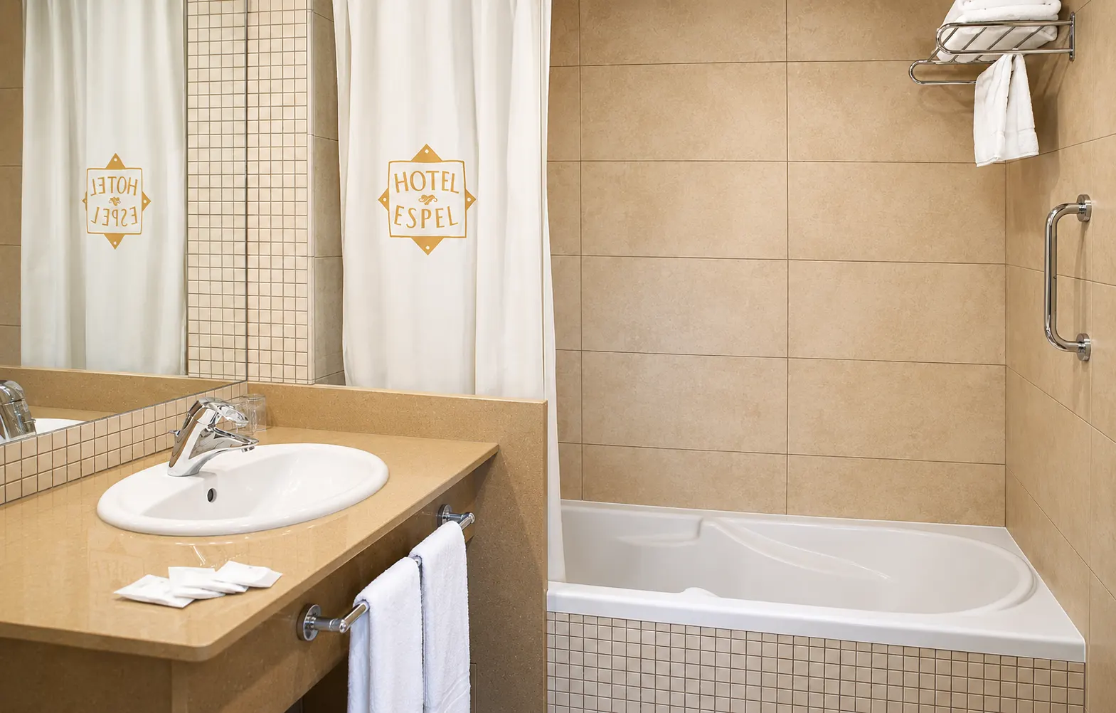 Baño con bañera y logo del hotel