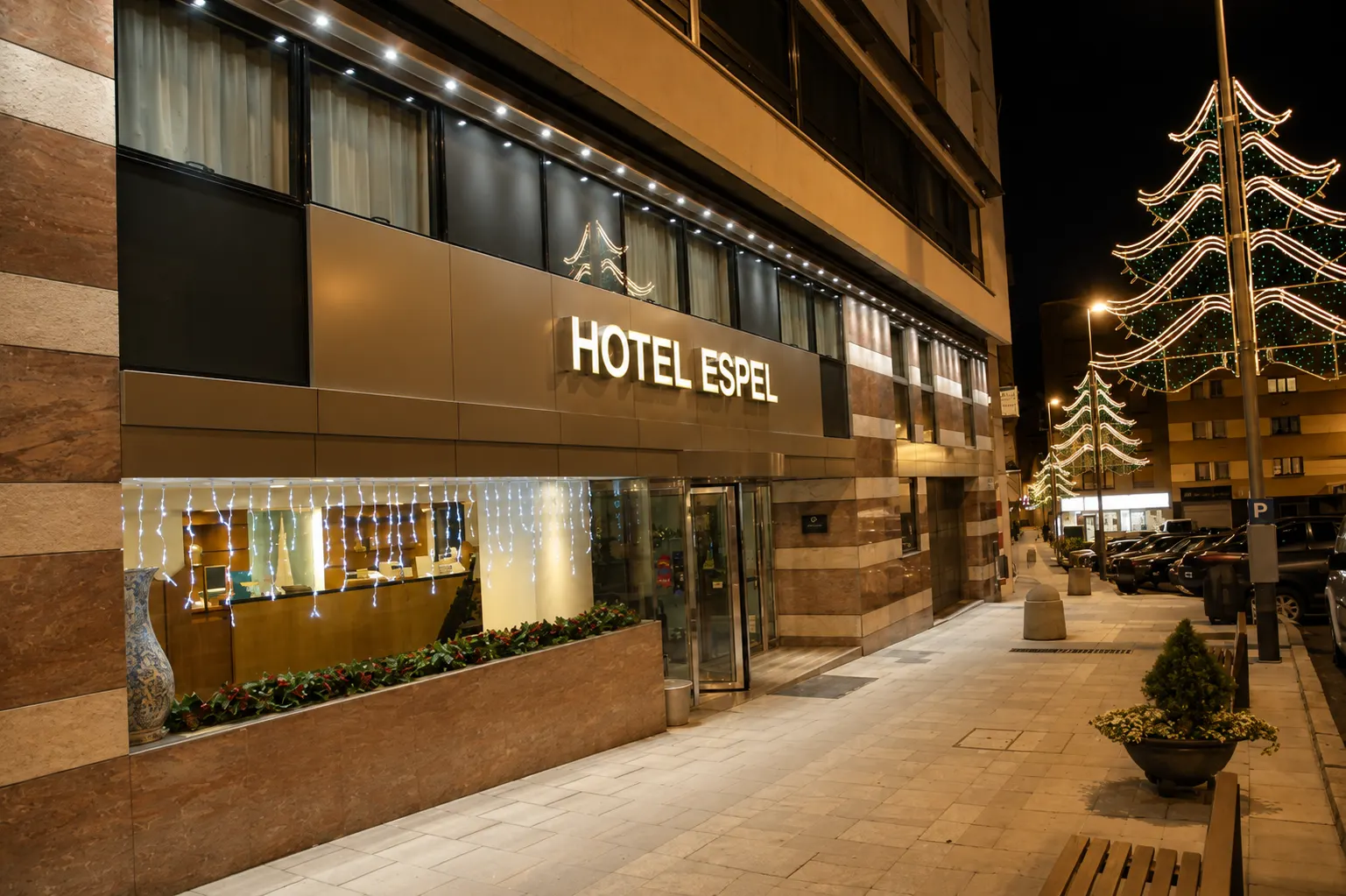 Fachada del Hotel Espel iluminada de noche